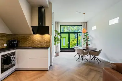 a kitchen and living room with a table and chairs at Stylish apartment next to the Amstel River - Unit A in Amsterdam
