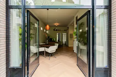a room with glass doors and a table and chairs at Stylish apartment next to the Amstel River - Unit A in Amsterdam