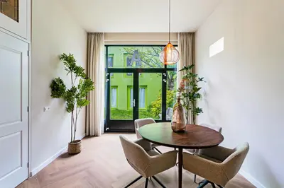 a dining room with a table and chairs and a window at Stylish apartment next to the Amstel River - Unit A in Amsterdam