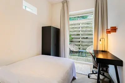 a bedroom with a bed and a desk and a window at Stylish apartment next to the Amstel River - Unit A in Amsterdam