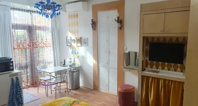 a living room with a kitchen with a table and a television at Studio Nieuwland in Alkmaar