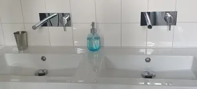 a bathroom with two white sinks and a blue bottle at Studio Nieuwland in Alkmaar