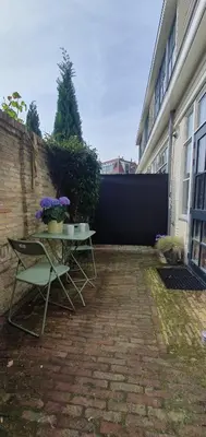 a patio with a table and chairs next to a building at Studio Nieuwland in Alkmaar