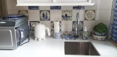 a kitchen counter with blue and white plates on the wall at Studio Nieuwland in Alkmaar