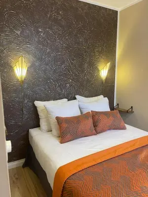 a bedroom with a bed with two lamps on it at Jupiter Hotel in Amsterdam