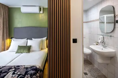 a bedroom with a bed and a sink and a toilet at Jupiter Hotel in Amsterdam