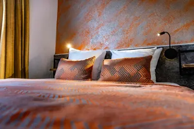 a bedroom with a large bed with pillows at Jupiter Hotel in Amsterdam