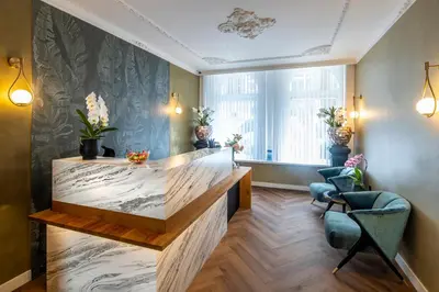 a lobby with a reception desk and chairs in a building at Jupiter Hotel in Amsterdam