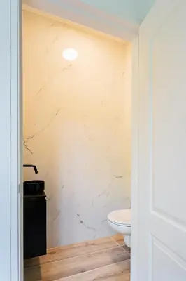 a bathroom with a toilet and a white wall at Stylish apartment next to the Amstel River - Unit C in Amsterdam