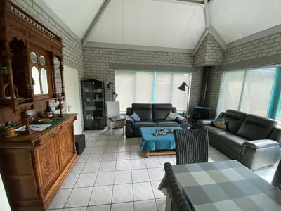 a living room with a couch and a table at Noordzee omheind met hond in Dirkshorn