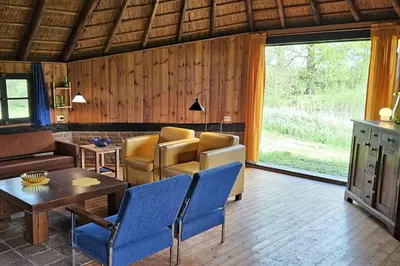 a living room with blue chairs and a table at Natuurhuisje op Landgoed Groot Diermen in Putten