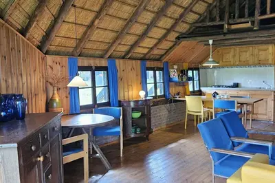 a kitchen and dining room with blue chairs and a table at Natuurhuisje op Landgoed Groot Diermen in Putten