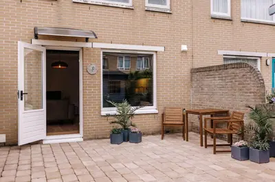 a patio with a table and chairs next to a building at Malu in Zandvoort