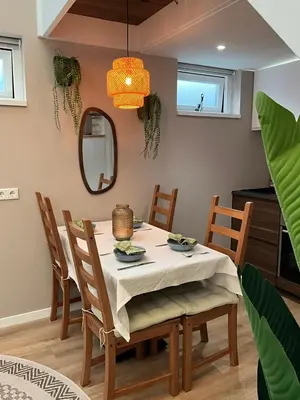 a dining room with a table with chairs and a mirror at Nieuwe vakantie woning nabij het strand - Egmond at the Beach House in Egmond aan Zee