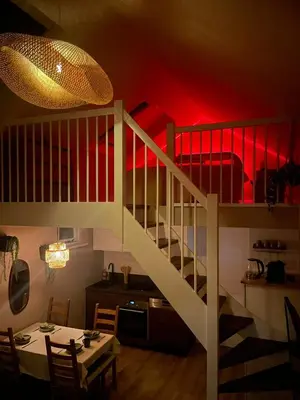 a room with a staircase with a table and a dining room at Nieuwe vakantie woning nabij het strand - Egmond at the Beach House in Egmond aan Zee