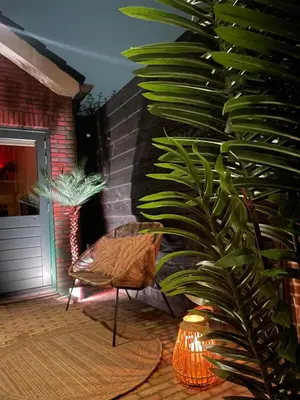 a living room with a chair and a plant at Nieuwe vakantie woning nabij het strand - Egmond at the Beach House in Egmond aan Zee