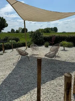 two chairs under aige umbrella on a gravel patio at Marina VILLA nabij water met prive sauna. in Spakenburg