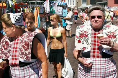 a man and a woman standing on a street at Marina VILLA nabij water met prive sauna. in Spakenburg