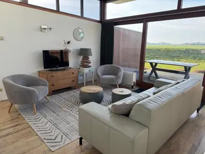 a living room with a couch and chairs and a tv at Marina VILLA nabij water met prive sauna. in Spakenburg