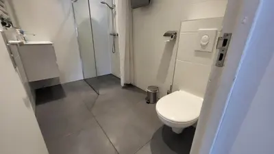 a small bathroom with a toilet and a shower at BnB Souterrain in Amsterdam