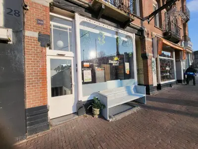a bench sitting in front of a store window at BnB Souterrain in Amsterdam