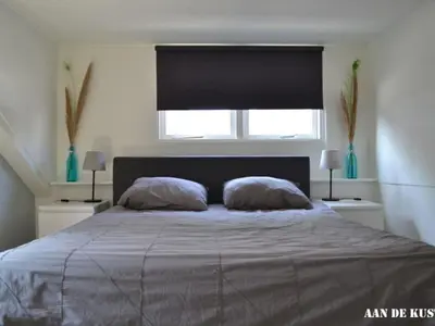 a bedroom with a bed with two pillows and a window at On the coast Comfortable holiday residence in Egmond aan Zee