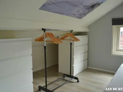 a bedroom with a bed and a dresser in it at On the coast Comfortable holiday residence in Egmond aan Zee