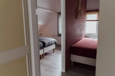 a small room with two beds and a window at Cosy bungalow with private garden in Noordwijkerhout