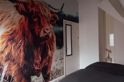 a painting of a bull on the wall of a bedroom at Cosy bungalow with private garden in Noordwijkerhout