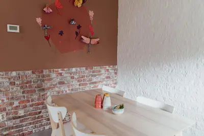 a dining room table with two chairs and flowers on the wall at Cosy bungalow with private garden in Noordwijkerhout