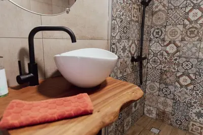 a white bowl on a wooden counter in a bathroom at Cosy bungalow with private garden in Noordwijkerhout