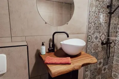 a bathroom with a bowl sink and a mirror at Cosy bungalow with private garden in Noordwijkerhout