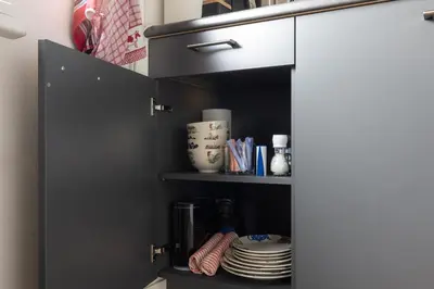 a cupboard with plates and dishes in it at Studio Hooischuur Alkmaar/Bergen in Alkmaar