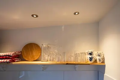 a shelf with glass jars and a wooden bowl at Studio Hooischuur Alkmaar/Bergen in Alkmaar