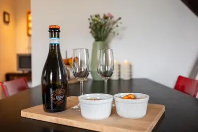 a bottle of wine and two wine glasses on a table at Studio Hooischuur Alkmaar/Bergen in Alkmaar