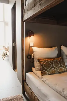 a bedroom with a bunk bed with a lamp on it at Strandhuisjes Zoomers aan Zee in Castricum
