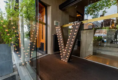 a facade of a building with a letter v on it at Hotel V Frederiksplein in Amsterdam