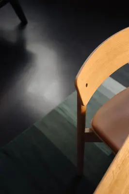 a wooden chair sitting next to a table at Hotel V Frederiksplein in Amsterdam