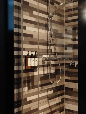 a bathroom with a shower with a glass door at Hotel V Frederiksplein in Amsterdam