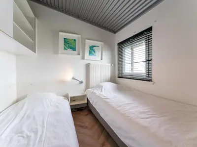two beds in a white room with a window at Beachhouse II in Bergen aan Zee
