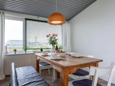 a dining room with a wooden table and chairs at Beachhouse II in Bergen aan Zee