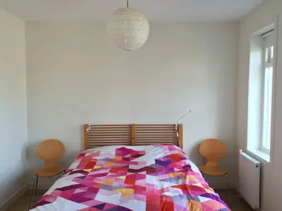 a bedroom with a colorful bed with two chairs at just like home in Haarlem