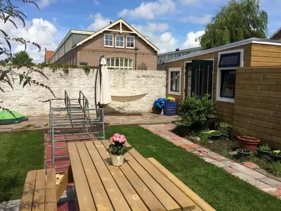 a backyard with a wooden bench and a house at just like home in Haarlem
