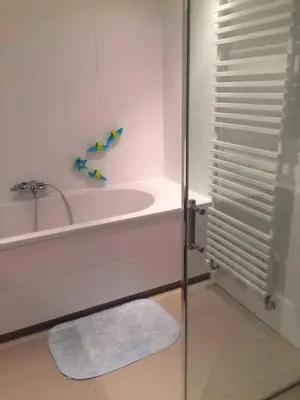 a white bathroom with a tub and a sink at just like home in Haarlem