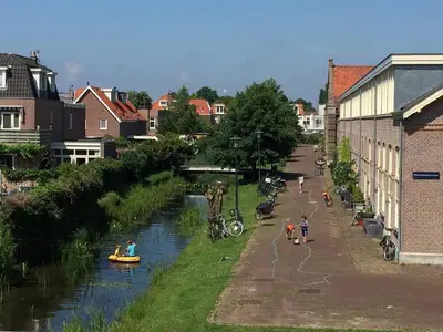a group of people in boats on a river at just like home in Haarlem