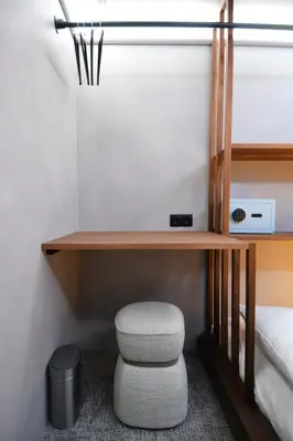 a small room with a desk and a stool at The Hyve Capsule hostel Amsterdam in Amsterdam