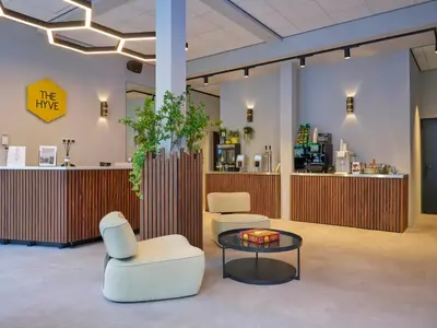 a lobby with two chairs and a table and a counter at The Hyve Capsule hostel Amsterdam in Amsterdam