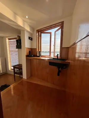 a kitchen with a sink and a large window at Casey's Lake View House Boat in Amsterdam