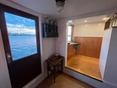 a door to a room with a view of the water at Casey's Lake View House Boat in Amsterdam