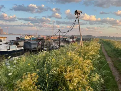 a camera on a pole next to a river with boats at Casey's Lake View House Boat in Amsterdam